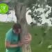 Un padre sostiene un árbol que había plantado su hija antes de morir